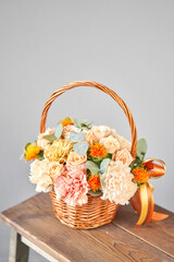 Fototapeta na wymiar Small flower shop and Flowers delivery. Flower arrangement in Wicker basket. Beautiful bouquet of mixed flowers in woman hand. Handsome fresh bouquet