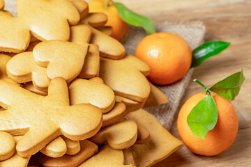 Gingerbread cookies and tangerines on a wooden table.