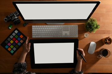 Female graphic designer hands using drawing tablet, computer and supplies