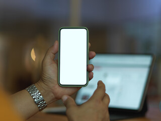 Male hand holding mock up smartphone in blurred background