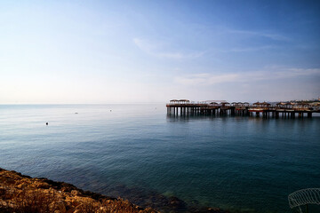 Rocky coast, sea, sky and pier in the background