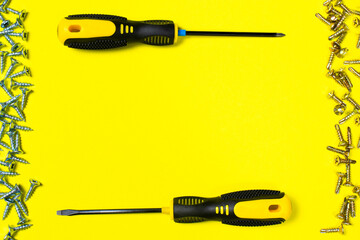 Self-cutters and two yellow screwdrivers on a yellow background with room for text. Banner with insides and fittings for a construction store or repair shop