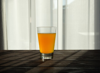 Orange juice in a glass glass on a wooden table.