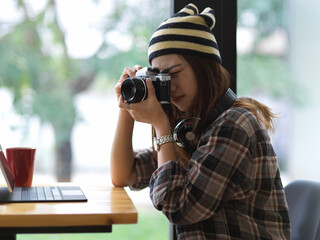 Portrait of female photographer taking photo with digital camera