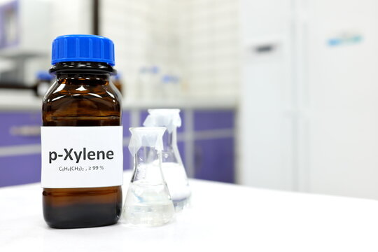 Selective focus of xylene liquid chemical compound in dark glass bottle inside a chemistry laboratory with copy space. Aromatic hydrocarbon used in petrochemical industry.