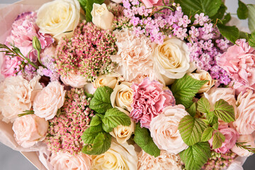 Beautiful spring bouquet on wooden table.. Arrangement with various flowers. The concept of a flower shop. A set of photos for a site or catalogue. Work florist.