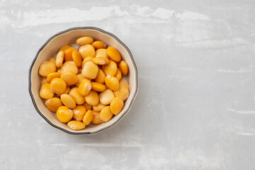 salted lupins in small light brown bowl on gray ceramic background