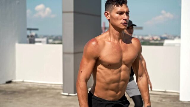 Shirtless handsome athletic men doing squat jump workout outdoors on rooftop, no equipment home exercise concept