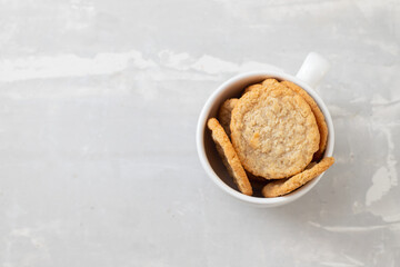 oat cookies in the white cup on ceramic background
