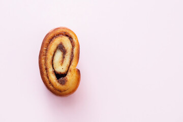 bun with cinnamon on pink background