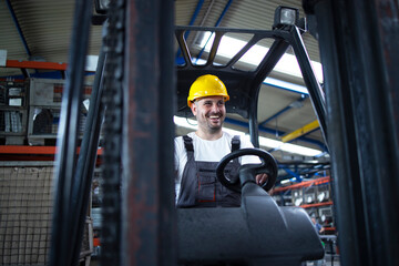 Professional worker industrial driver operating forklift machine in factory's warehouse.