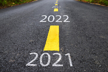 Number of 2021 to 2025 on  asphalt road with yellow line marking on road surface. Happy new year concept and productive idea