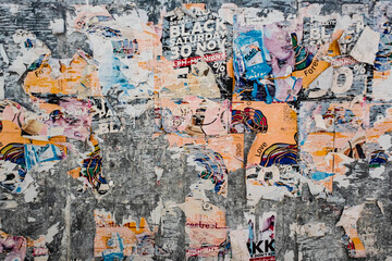 Texture of a bright wall with ruptures of posters and advertising. Bright abstract background