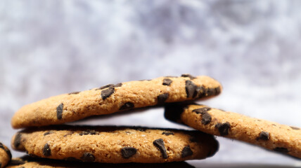 American chocolate chip cookies stacked on top of each other on a beautiful gray marble background. Traditional rounded crunchy dough with chocolate chips. Bakery. Delicious dessert, pastries.
