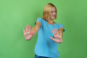 Young woman with colored blond hair gesturing stop and distance