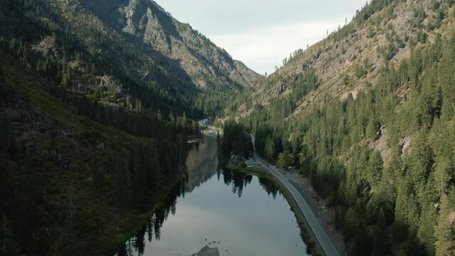 Drone View of Calm Wenatchee River Water Reflecting Trees and Mountain Cliffs
