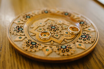Engagement wedding rings. Gold couple rings on a plate. wedding ceremony in christian church. close up. Selective focus. Photo in motion.