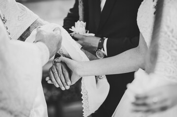 Hands of bride and groom tied Wedding towel. The priest binds the bride's hand towel. hands of...