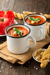 Tomato and fresh basil soup with garlic, cracked papper corns, served with cream and bread
