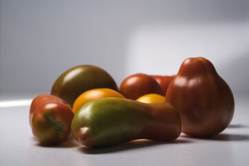 a separate pile of tomatoes of different shapes and colors