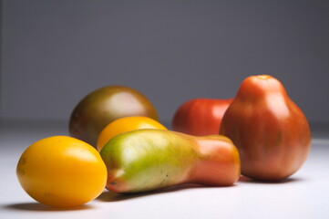 a separate pile of tomatoes of different shapes and colors