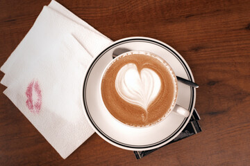 Close up coffee cup with latte art milk foam on wood table, top view