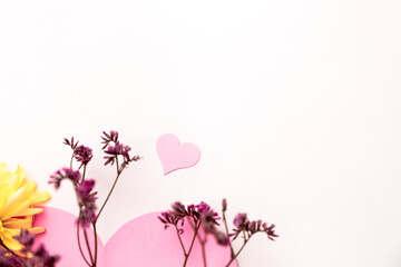 A large pink heart with a place for text decorated with small pink flowers on a white background