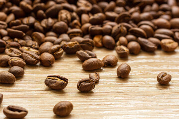 Roasted arabica coffee beans scattered in a heap on the table.
