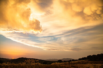 Cielo con impresionantes nubes amarillentas entre montañas