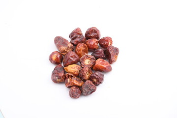 A molehill of a handful of round chilis scattered on a plain white background.