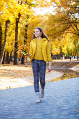 Blonde teenage girl posing in autumn park