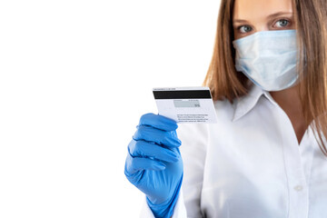 Bank payments. Quarantine measures. Personal offer. Woman in white shirt medicine mask gloves holding credit card looking at camera isolated on neutral copy space. Advertising background