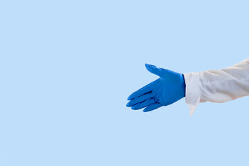 Welcome gesture. Covid-19 safe. Back work. Open palm. Unrecognizable female hand in protective gloves white shirt showing copy space isolated on light blue. Advertising background.