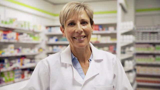 Female pharmacist smiling loving her work standing in clean pharmacy 