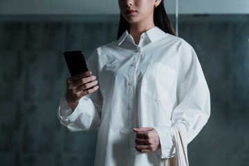 Woman in white shirt and smartphone.