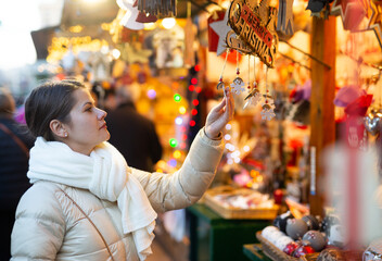 Woman is choosing decorations for Christmas tree in the market. High quality photo