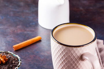 Masala chai tea. Traditional indian drink - masala tea with spices on dark background. Ceramic cup...