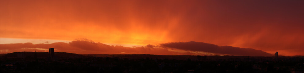 High resolution panorama of scenic sunset. Autumn red and orange sunset, end of the rain.