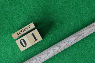 August 1, Number cube with a snooker stick on a green background, snooker table.