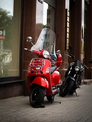 Rolgordijnen Red, beautiful moped / scooter parked on the street by the building wall. © KILO LUX