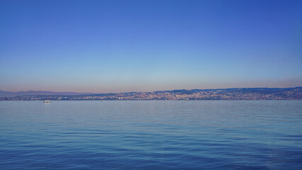 Beautiful calm waters of Lake Geneva with Lausanne cityscape. Canton of Vaud in Romandy, Switzerland.
