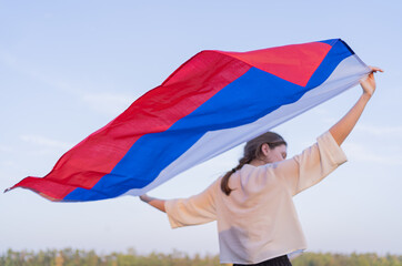 The flag of Russia beautifully waving behind the back of a woman. Russia's Independence Day