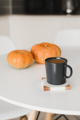 Homemade coffee with cinnamon, milk and pumpkin served on a white table. Fall season beverage