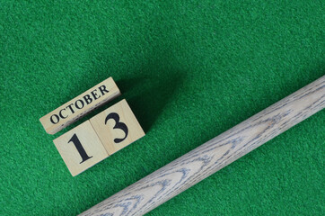 October 13, Number cube with a snooker stick on a green background, snooker table.