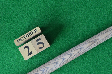 October 25, Number cube with a snooker stick on a green background, snooker table.