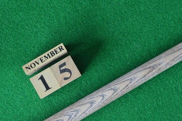 November 15, Number cube with a snooker stick on a green background, snooker table.
