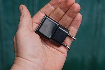 one black plastic charger lies on open palm