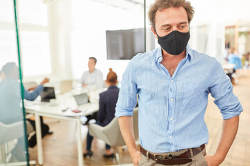Business Mann im Büro mit Mund-Nasen-Schutz