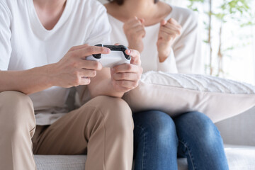 家でゲームをするアジア人カップル