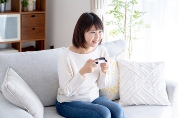 家でゲームをするアジア人女性